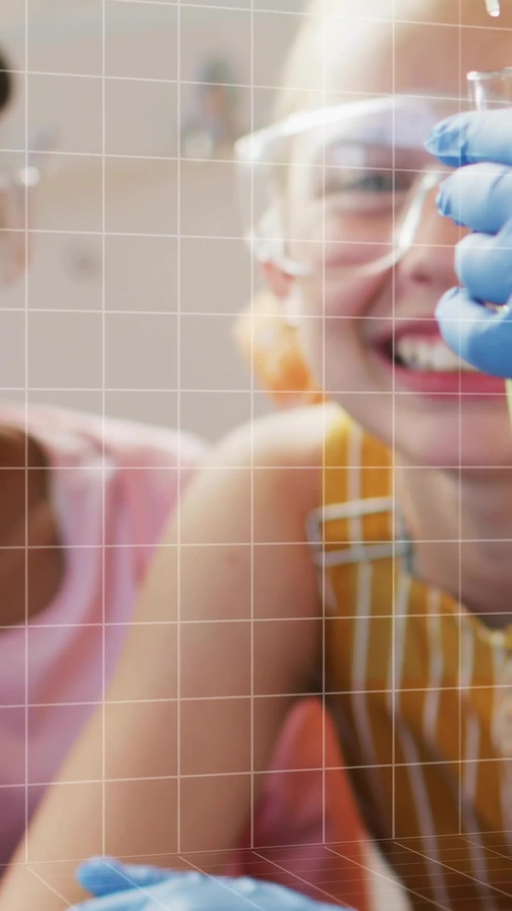 Vídeo vertical: Menina usando pipeta liberando uma gota, grade pixelizando enquanto colegas observam para STEM.