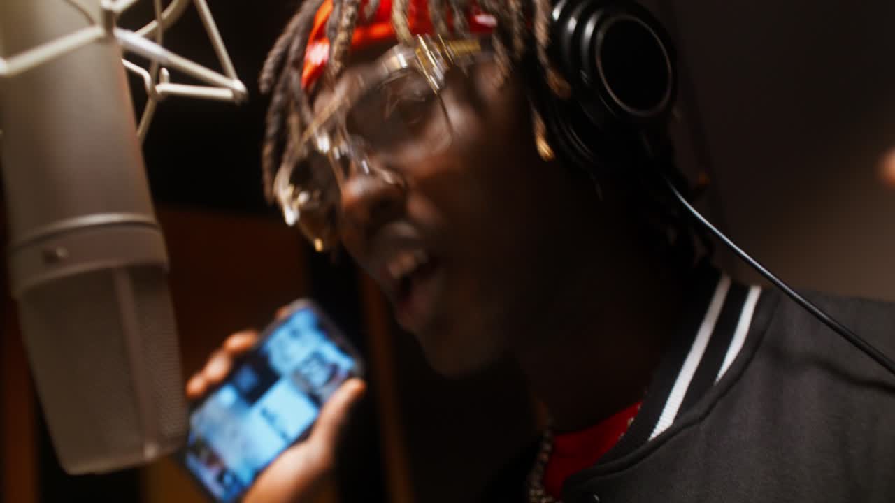 hombre cantando en un micrófono en un estudio de grabación