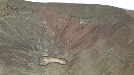 Aerial-view-descending-into-Bayuyo-volcano-crater-rugged-Fuerteventura-Las-Palmas-landmark