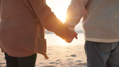 sunset, beach and closeup of couple holding hands