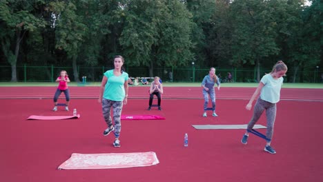 work out with fitness training instructor. large group of young people stretching outdoor