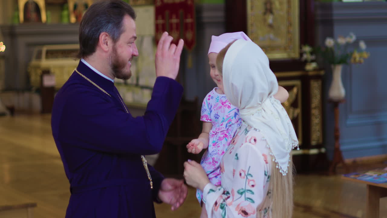 여자와 아이가 제사장에게 다가오고 있다.