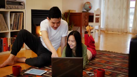 couple using laptop in living room