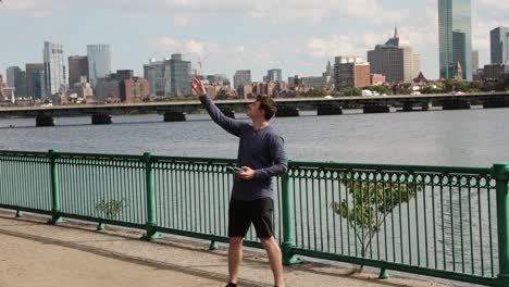 Professional-drone-pilot-catch-aircraft-in-hand-after-flight,-Boston-city