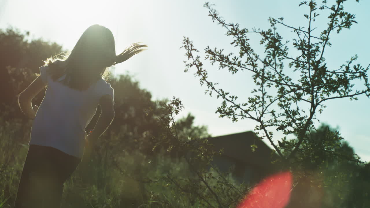 해가 지는 동안 들판을 가로질러 달리는 아이