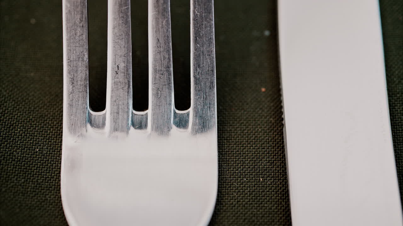 Close up of a fork and a table knife on a green napkin