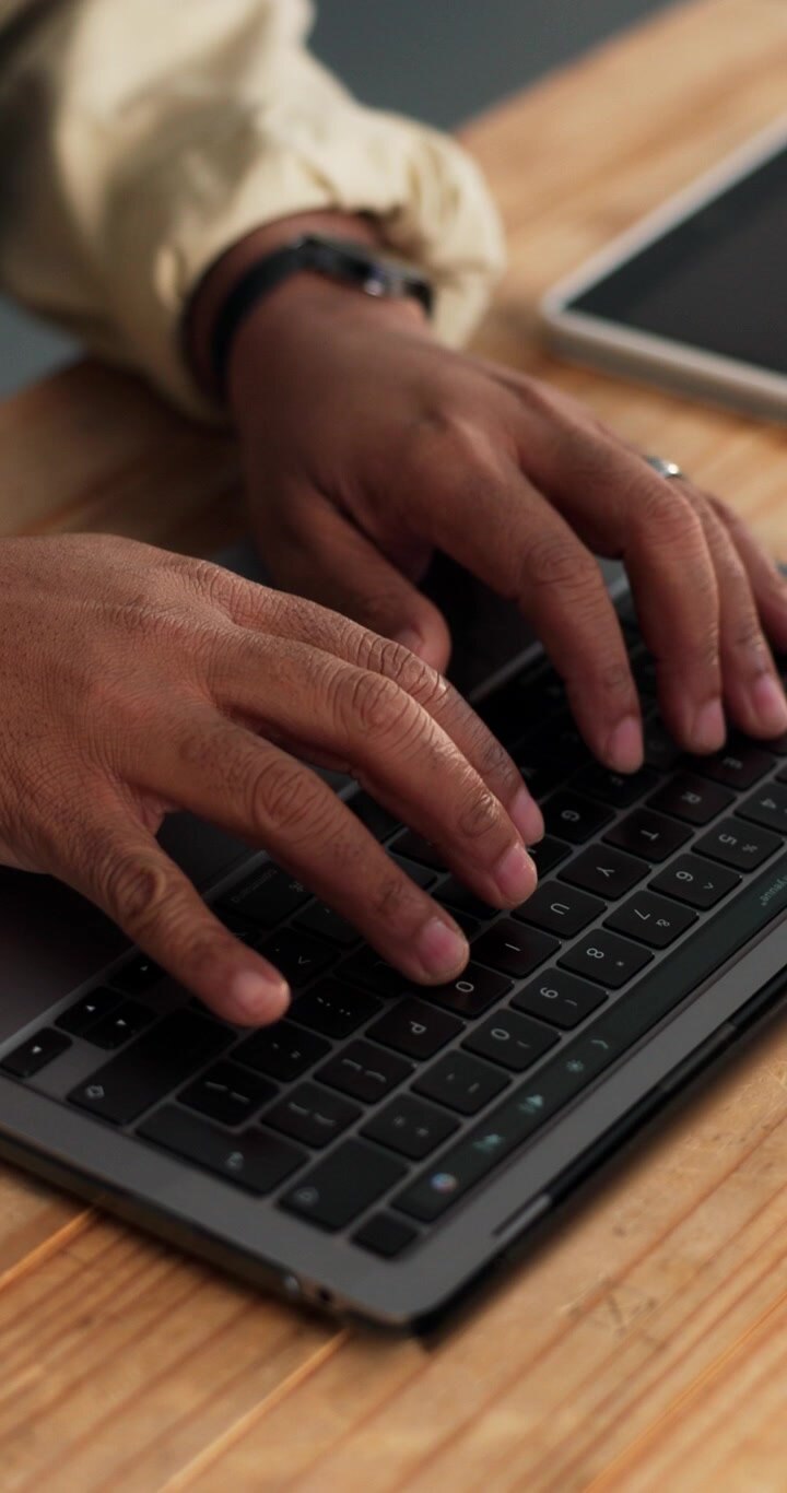 Primo piano di una persona che digita sulla tastiera di un laptop