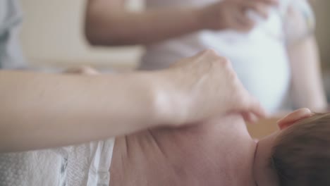 little-boy-lies-on-side-and-nurse-makes-arm-massage