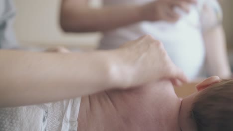 little boy lies on side and nurse makes arm massage