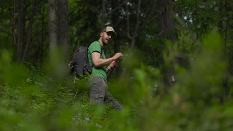 joven en el bosque configurando la grabación de video usando un teléfono inteligente y un palo