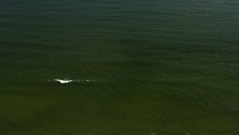 slow aerial drone camera pan left over shoreline then tilts up towards the horizon