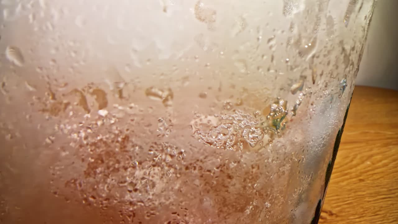 Condensa e ghiaccio che si scioglie sul vetro con panoramica lenta e riflessi tenui