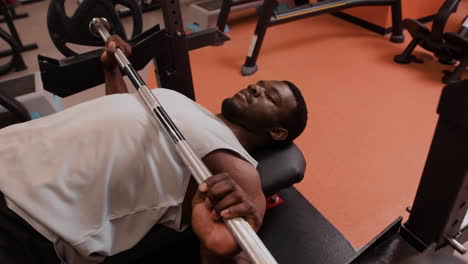 hombre realizando ejercicio de press de banca en el gimnasio