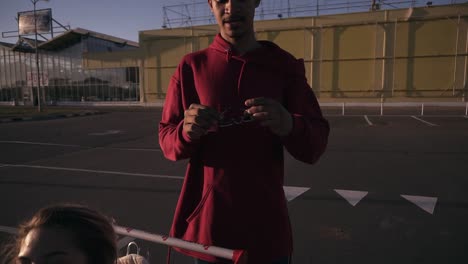 Hombre-Joven-De-Piel-Oscura-Elegante-Con-Tonos-De-Moda-Y-Camisa-Roja-Sosteniendo-Y-Luego-Poniéndose-Las-Gafas-De-Sol