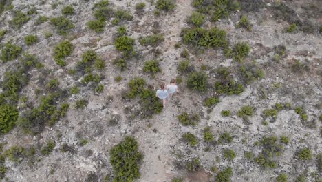 Two-hikers-walking-on-a-path-in-Alcoi-mountains,Valencia,Spain,aerial