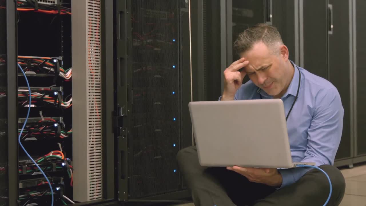 Technician using laptop to analyse server