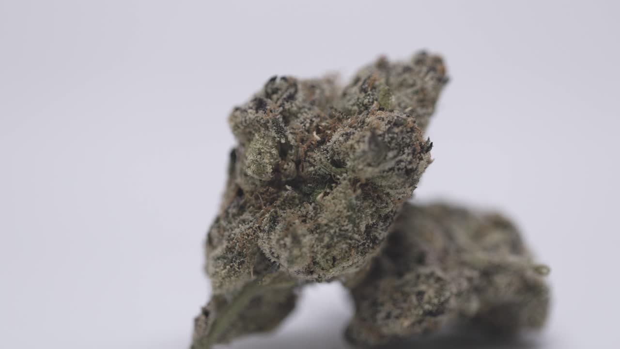 Stack of cannabis buds on a white background with a focus bokeh.