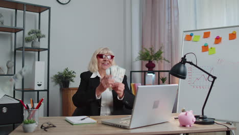 Business-woman-accountant-celebrating-business-success-dancing-with-stack-of-money-dollar-cash