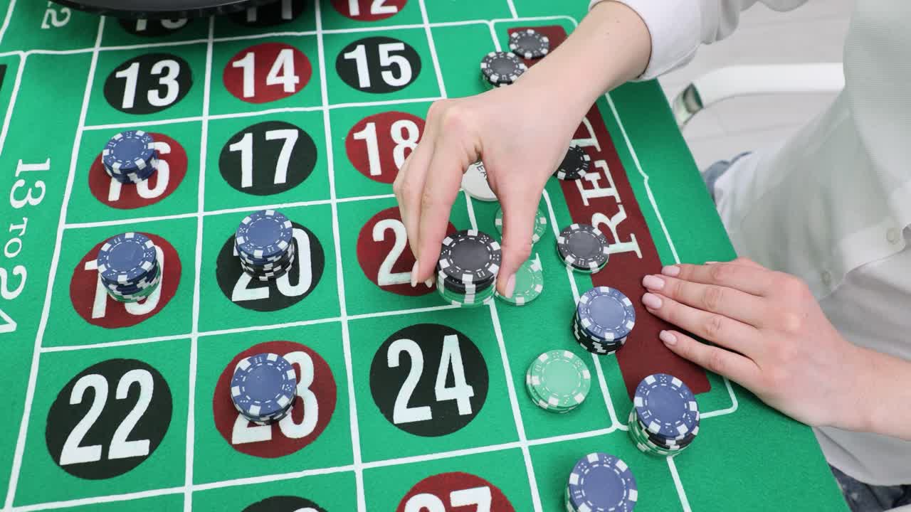 Giocatore impila fiches da casinò sul tavolo della roulette, puntando sui numeri