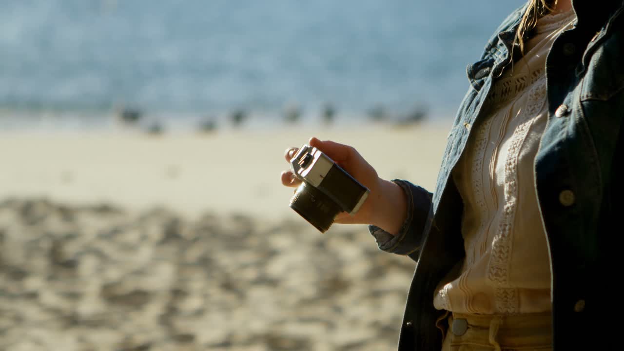 해변 4k에서 카메라로 사진을 찍는 여자