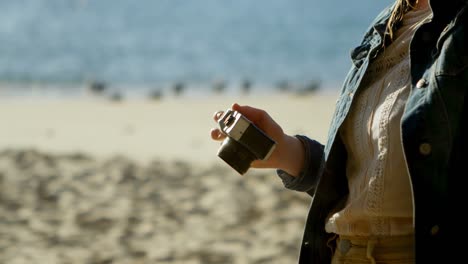 woman clicking photo with camera at beach 4k