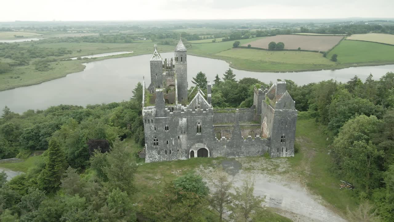 Gothic Revival Style Of Dromore Castle Abandoned On Top Of Hill In County Limerick, Ireland. aerial orbiting
