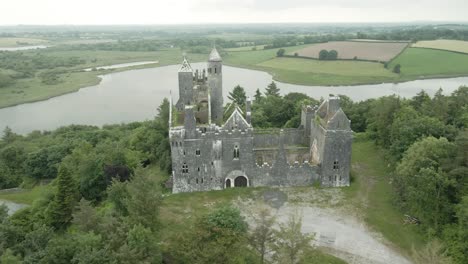 gothic revival style of dromore castle abandoned on top of hill in county limerick, ireland. aerial orbiting