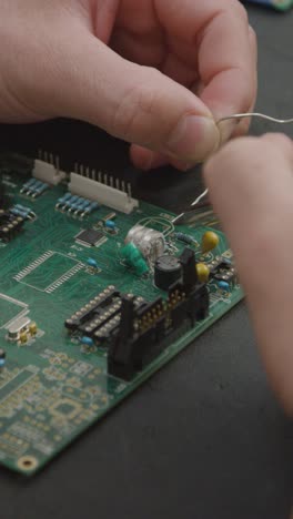 vertical shot of student soldering circuit board