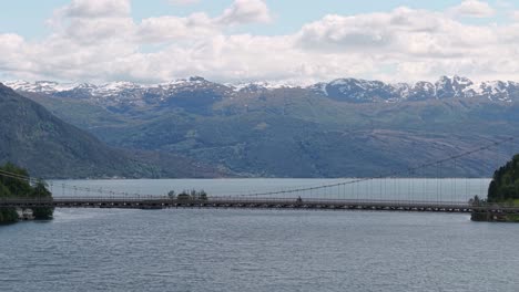 bicycle across the fyksesund suspension bridge in vestland county, norway. wide shot