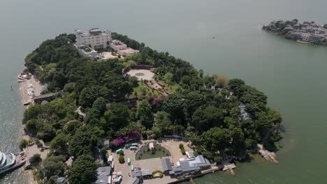 Horizontal-panning-drone-footage-of-Nanzhao-Amorous-Island-and-the-surrounding-ancient-city-of-Xi-Zhou-in-Dali,-Yunnan,-China