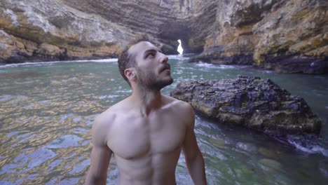 un joven caminando por los acantilados del mar.
