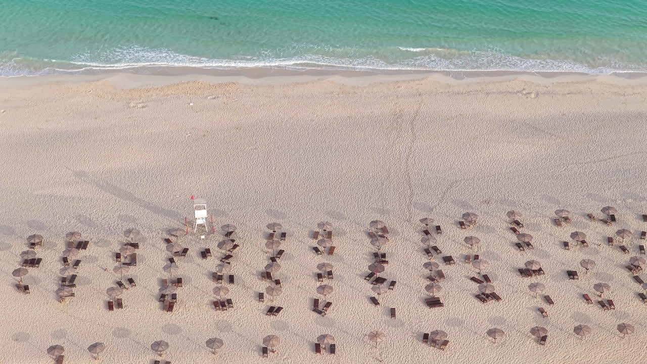 Panning shot of of sandy beach, parasol, Atlantic ocean and luxury resort at Praia de Chaves (Chaves beach), Boa Vista, Cabo Verde (Cape Verde)
