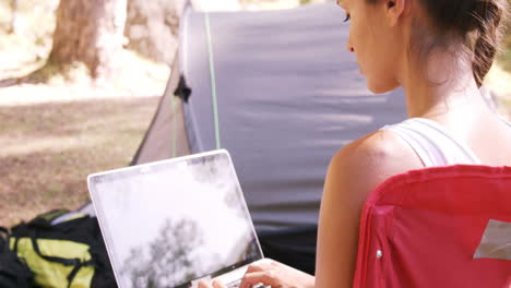 mujer usando una computadora portátil fuera de la tienda