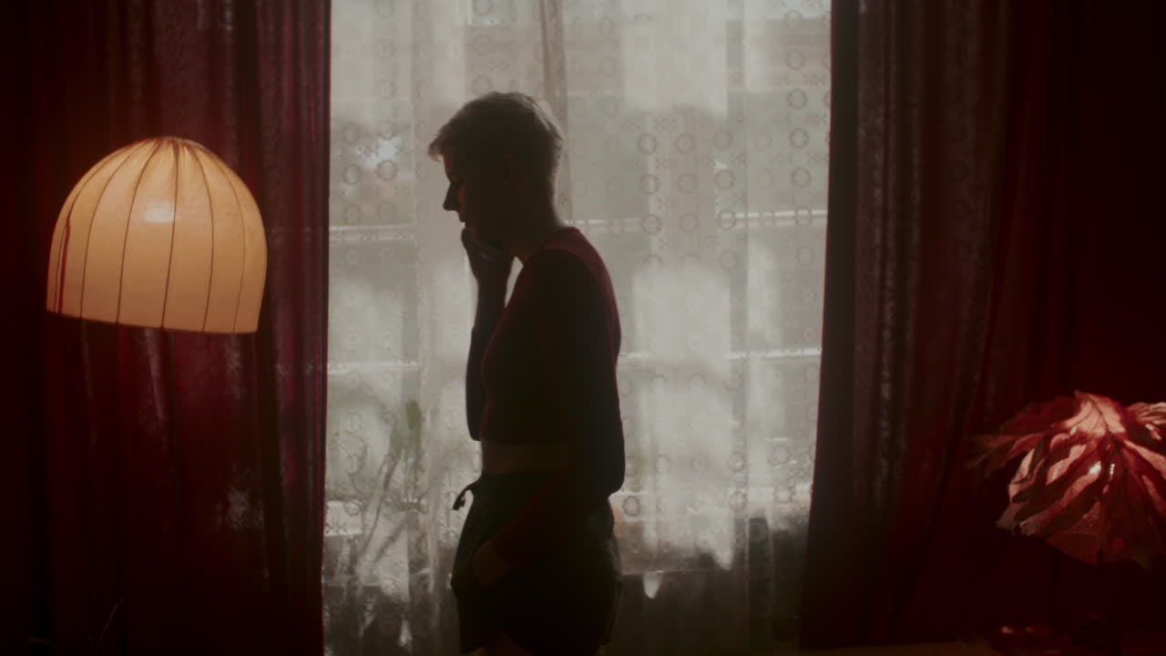 Woman Talking on Phone by Window