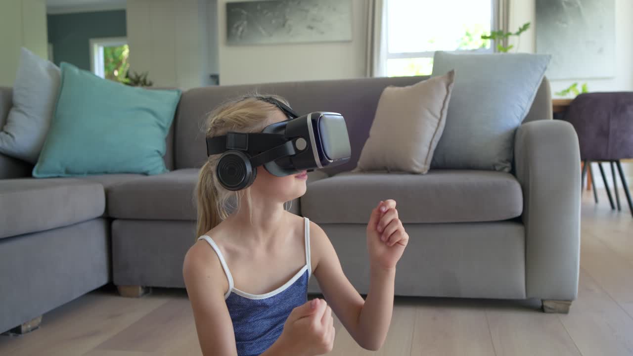 Niña con gafas de realidad virtual (VR) negras, activando auriculares, alcanzando un volante en el suelo y explorando la RV.