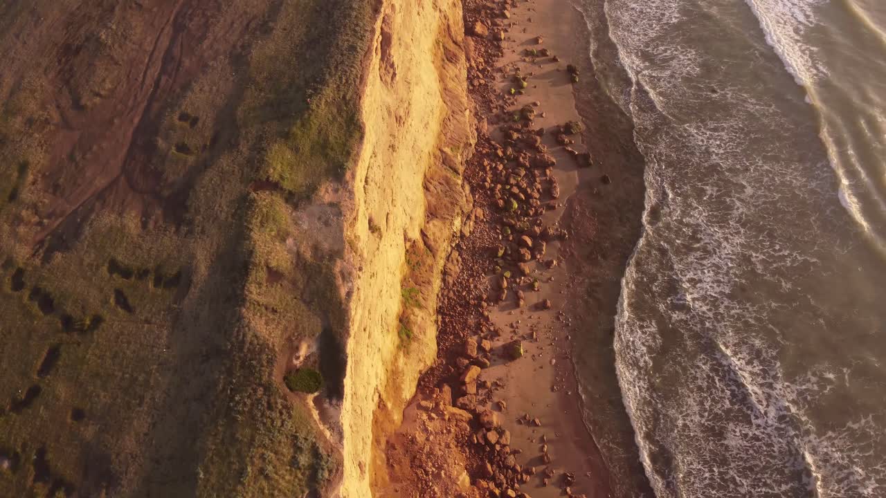 toma en cámara lenta de los acantilados al atardecer, hermosa vista de arriba hacia abajo de las olas de agua moviéndose de un lado a otro en acantilados mar del plata, sudamérica