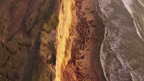 slow motion shot of the cliffs at sunset, beautiful top down view of the water waves moving too and fro in acantilados mar del plata, south america