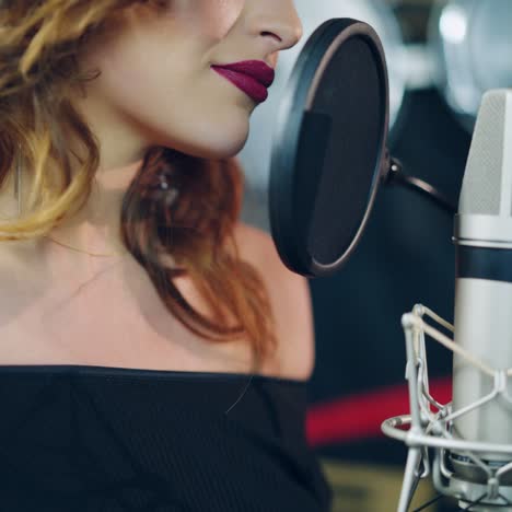professional musician recording new song or album in studio. woman singing in the recording studio.