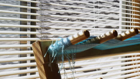 Close-up-of-threads-on-wooden-inkle-loom-in-a-empty-workshop-4k