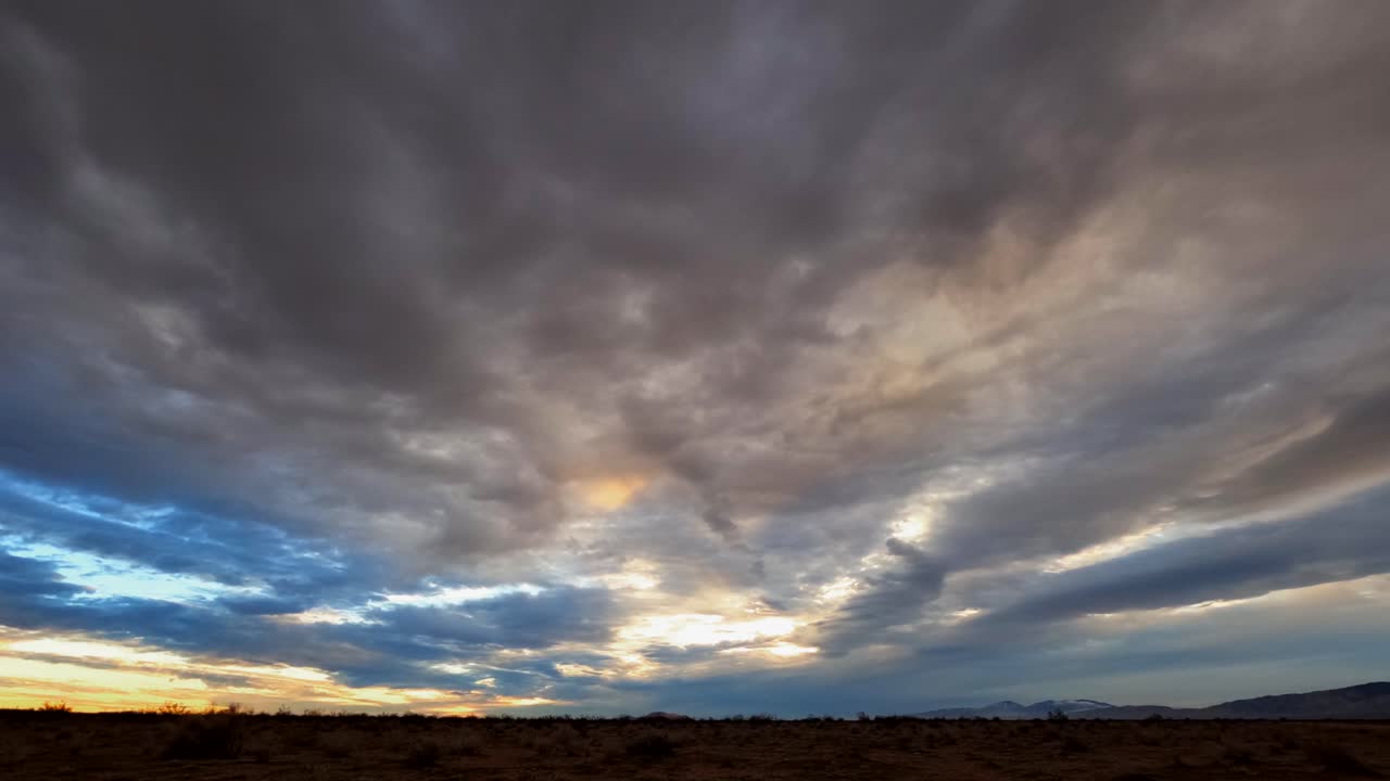 espectacular cielo nublado sobre el duro y accidentado paisaje del desierto de mojave - lapso de tiempo de gran angular
