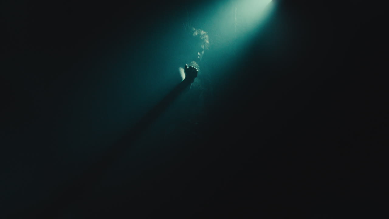 The witch makes a beckoning gesture with her hand