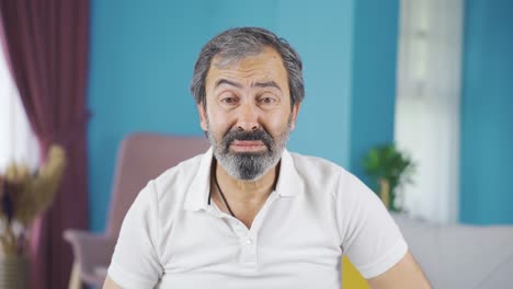el anciano mira a la cámara con una expresión triste.