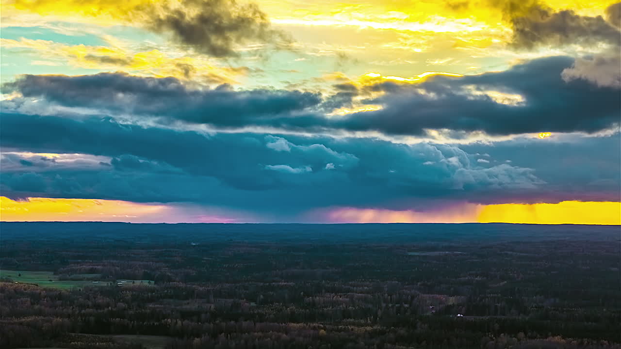 Storm clouds over golden skyline sunset sunrise in rural Latvia nature forest