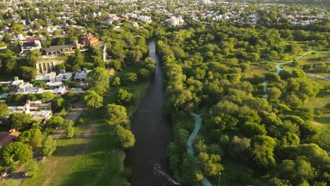 aerial flyover beautiful suquia river surrounded by green area in cordoba city in argentina during summer