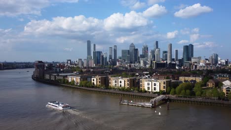 Statische-Drohnenaufnahme-Von-Canary-Wharf-In-London-Mit-Boot-Auf-Der-Themse