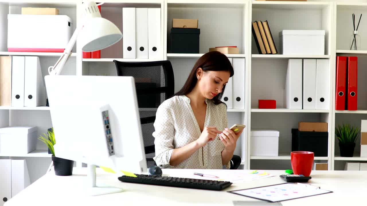 businesswoman sitting in office-chair and using smartphone