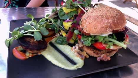 Gourmet-Hamburger-Mit-Beilagensalat-Auf-Schwarzem-Teller-Und-Minzsoße