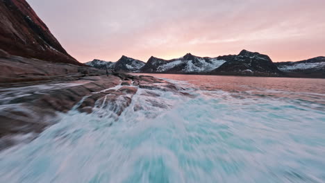 coastal waves crashing onto rocky shore at tungeneset, senja during sunset