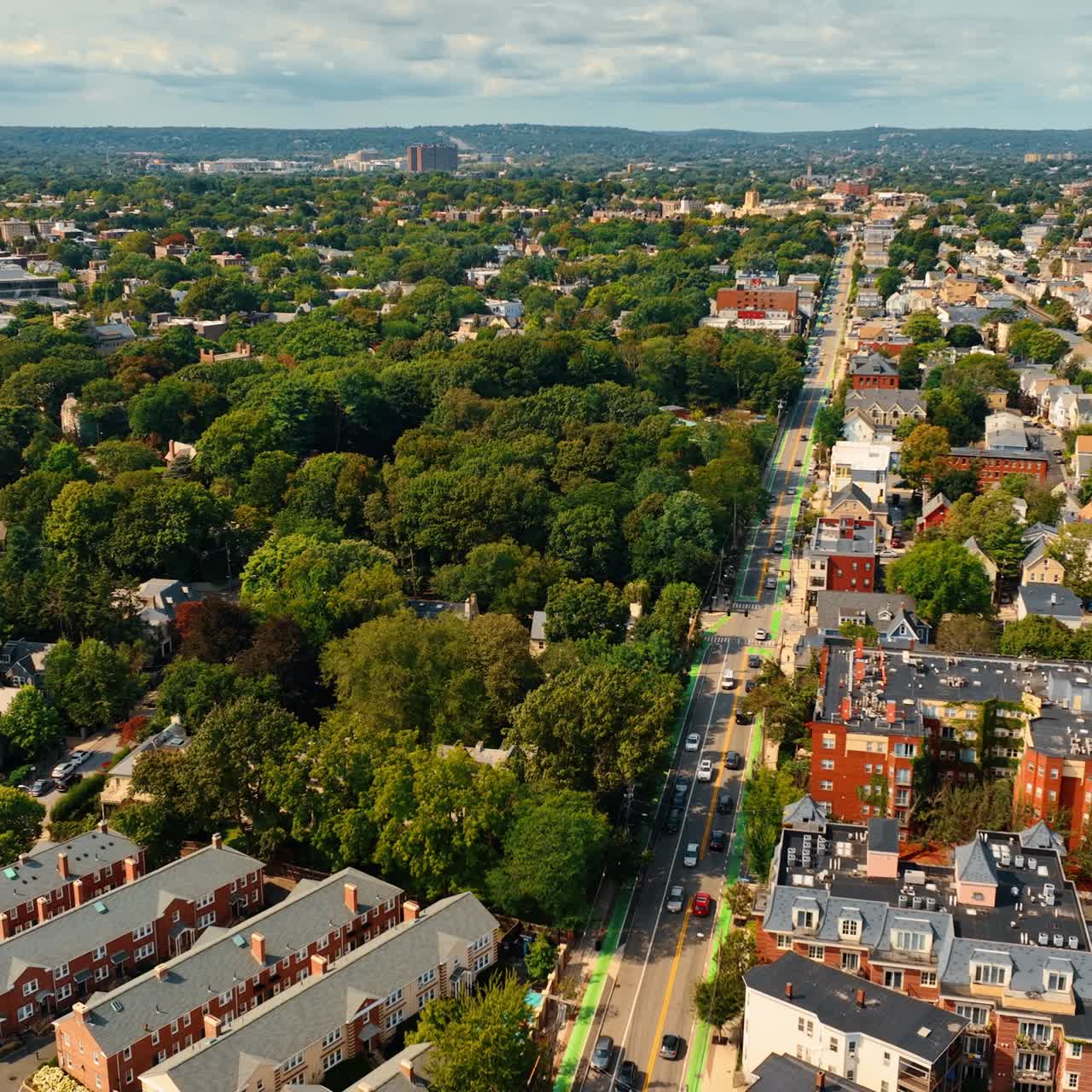 Rising over rooftops of low-rise buildings in Cambridge, Massachusetts, USA. Green city scenery on sunny day from top