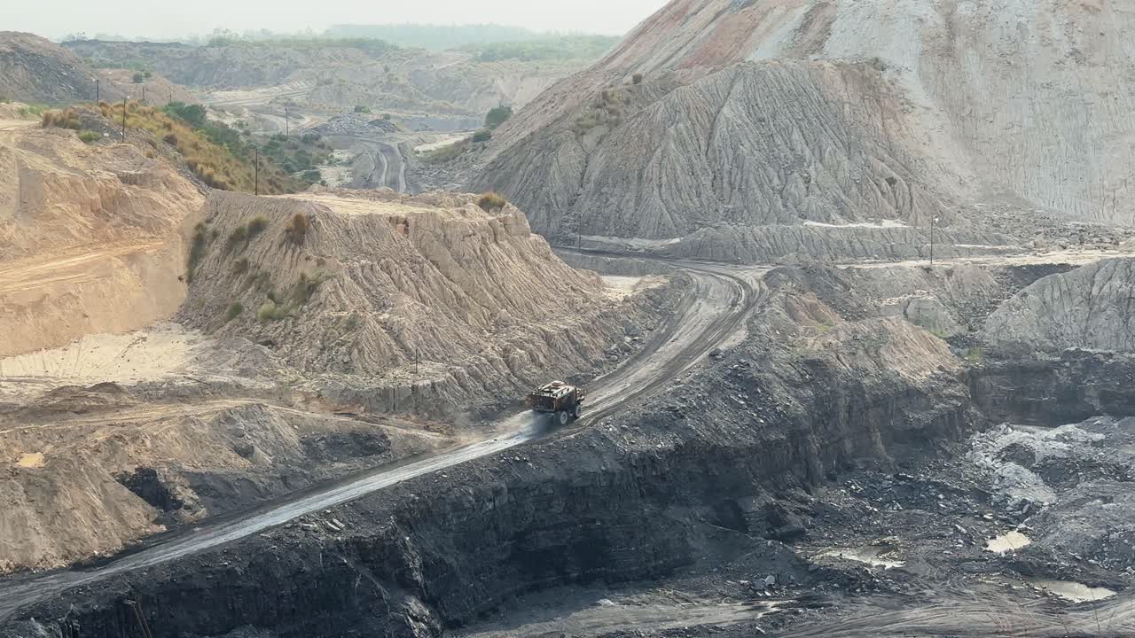 A large mining dump truck is spraying water on the roads inside coal mines for dust suppression and to mitigate the health hazards associated with airborne dust and maintain safe working conditions